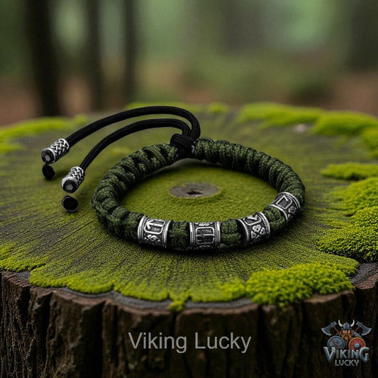 Green braided bracelet with metal beads on a wooden stump with 'Viking Lucky' branding.