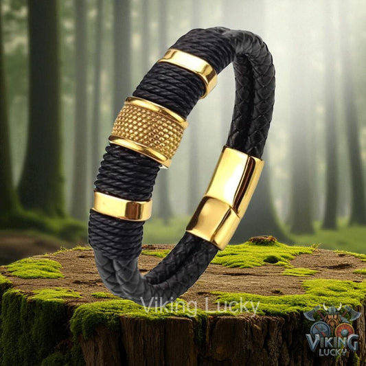 Black braided bracelet with gold accents on a wooden stump in a forest setting, featuring the brand 'Viking Lucky'.
