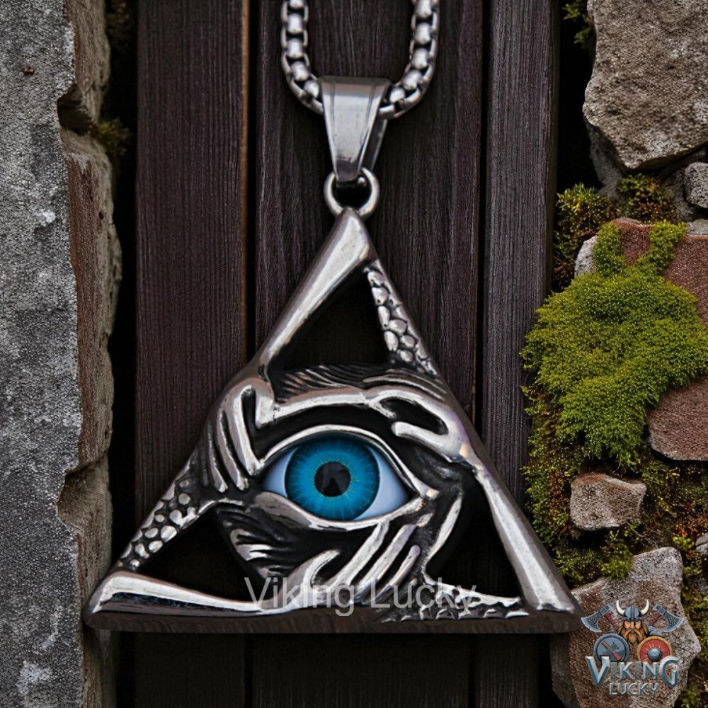 Silver eye-shaped pendant with blue gemstone on a wooden background