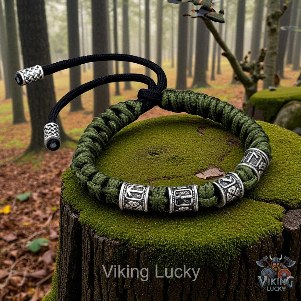 Green braided bracelet with silver beads on a mossy tree stump in a forest setting, featuring 'Viking Lucky' branding.