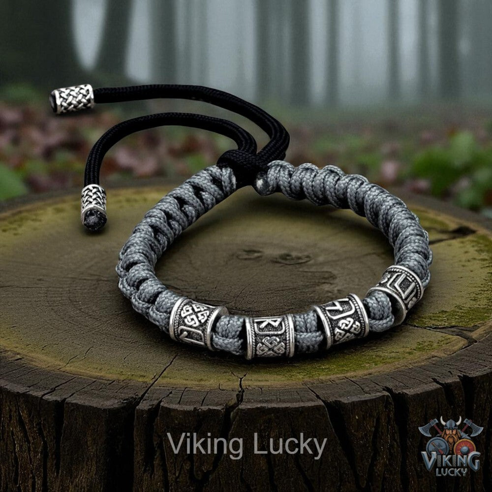 Gray braided bracelet with silver accents on a wooden stump, featuring 'Viking Lucky' branding.