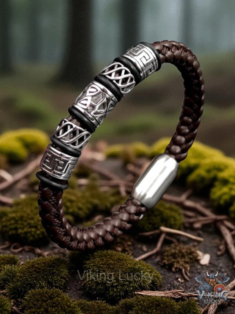 Brown braided bracelet with silver metal elements on a forest floor background