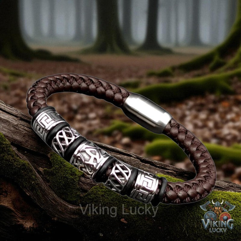 Brown braided leather bracelet with silver accents on a wooden log in a forest setting, featuring 'Viking Lucky' branding.