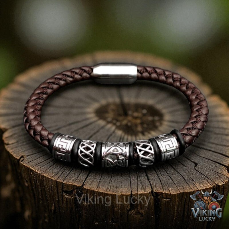 Brown braided leather bracelet with silver beads on a wooden stump, featuring 'Viking Lucky' branding.