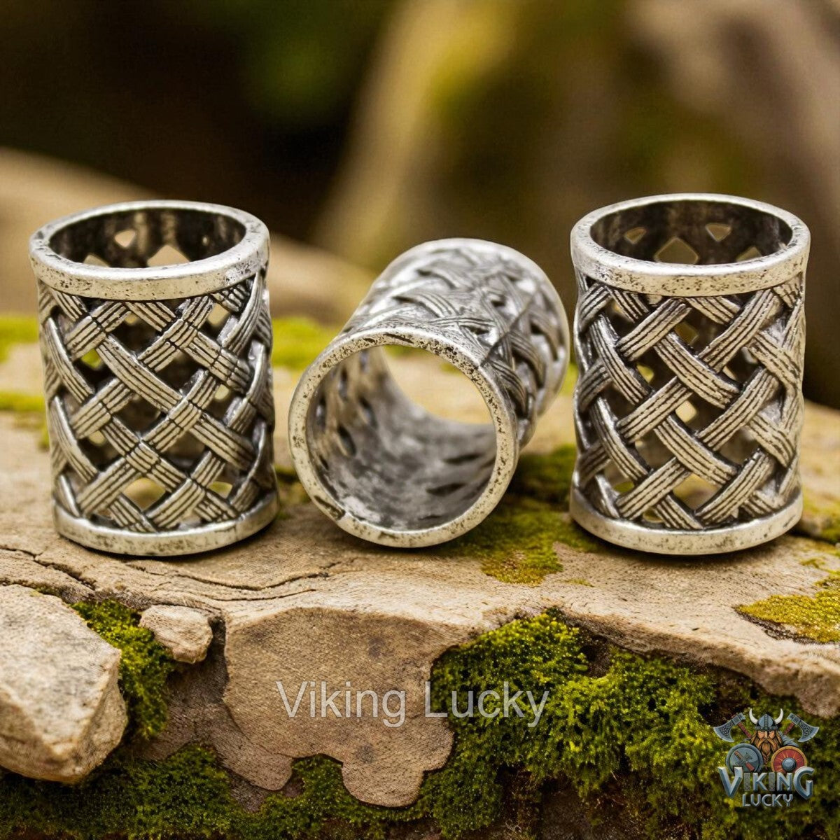 Three silver rings with intricate designs on a stone surface, branded 'Viking Lucky'.