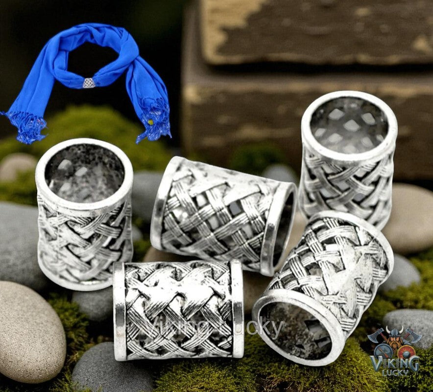 Silver Viking-style necklaces on stones with a blue scarf in the background
