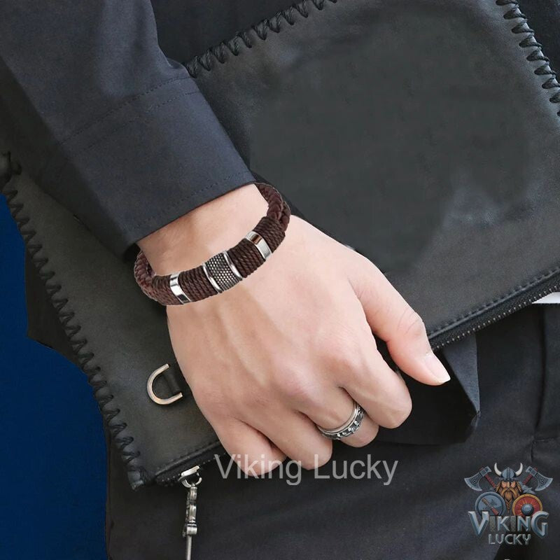 Hand wearing a bracelet with a visible brand logo, close-up shot.