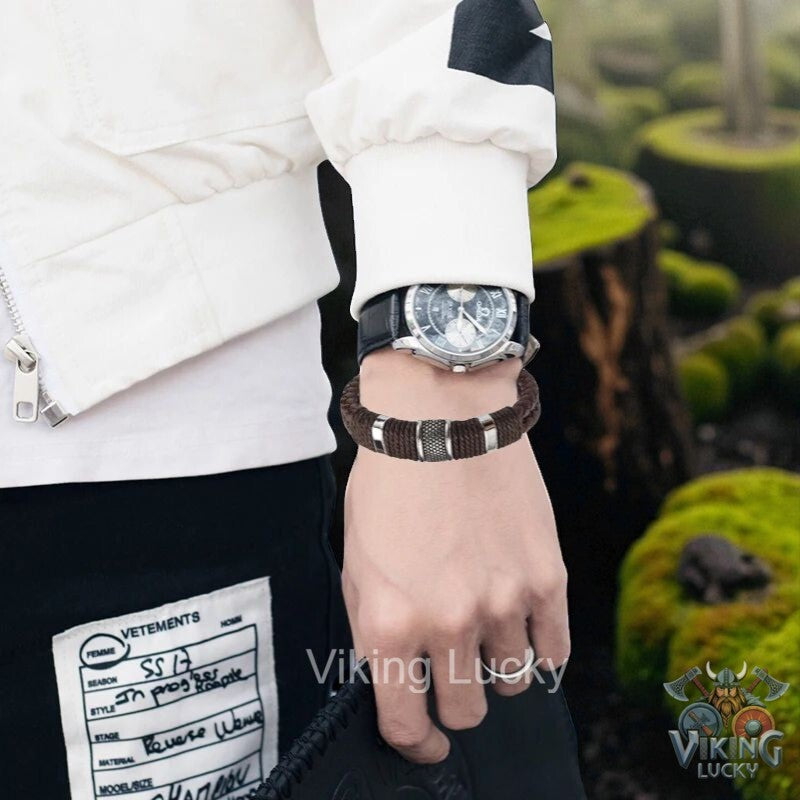 Person wearing a watch with a visible brand logo, standing outdoors.