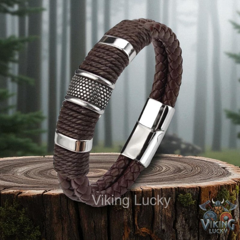 Brown braided bracelet with silver accents on a wooden stump, branded 'Viking Lucky'.