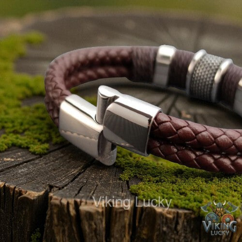 Brown leather bracelet with silver clasp on a wooden surface, featuring 'Viking Lucky' branding.