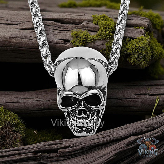 Silver skull pendant necklace on a wooden background