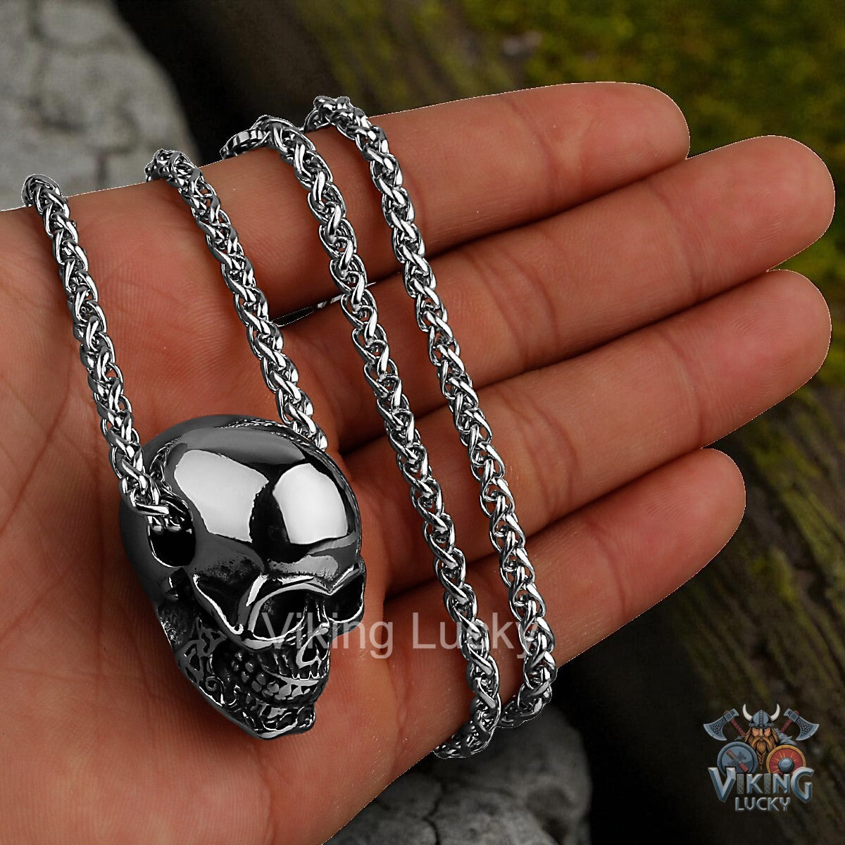 Skull pendant on a chain held in a hand with 'Viking Lucky' branding.