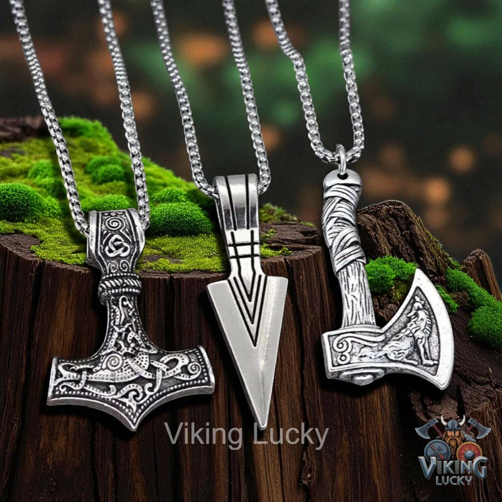 Three Viking-style necklaces on a wooden block with grass, featuring 'Viking Lucky' branding.